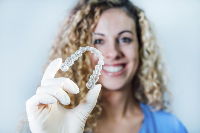 Female doctor holding a transparent dental aligner